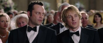 Movie still from “Wedding Crashers” (2005), directed by David Dobkin – A couple of men in tuxedos standing next to each other; Close Up shot, Over the shoulder angle