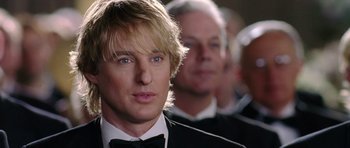 Movie still from “Wedding Crashers” (2005), directed by David Dobkin – A person wearing a suit and bow tie; Close Up shot, Over the shoulder angle