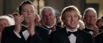 Movie still from “Wedding Crashers” (2005), directed by David Dobkin – A group of men in tuxedos smiling for a picture; Close Up shot, Over the shoulder angle