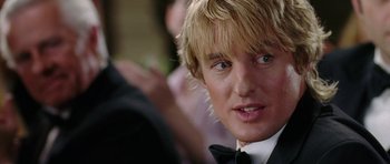Movie still from “Wedding Crashers” (2005), directed by David Dobkin – A person wearing a suit and bow tie; Close Up shot, Over the shoulder angle