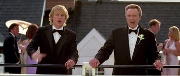 Movie still from “Wedding Crashers” (2005), directed by David Dobkin – Two men in tuxedos standing next to each other in front of a building; Medium shot, Low angle