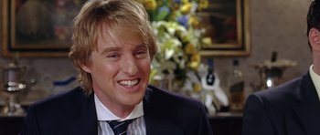 Movie still from “Wedding Crashers” (2005), directed by David Dobkin – A person wearing a suit and smiling; Close Up shot, Over the shoulder angle
