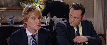 Movie still from “Wedding Crashers” (2005), directed by David Dobkin – A couple of men sitting next to each other at a table; Close Up shot, Over the shoulder angle