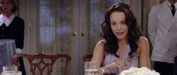 Movie still from “Wedding Crashers” (2005), directed by David Dobkin – A woman sitting at a table with a glass of water; Close Up shot, Over the shoulder angle