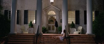 Movie still from “Wedding Crashers” (2005), directed by David Dobkin – A woman sitting on the steps of a building next to a man in a suit; Wide shot, Low angle