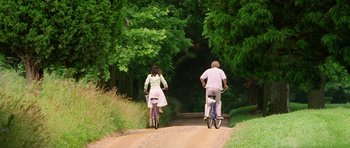 Movie still from “Wedding Crashers” (2005), directed by David Dobkin – A man and a woman riding bikes down a dirt road; Wide shot, Low angle