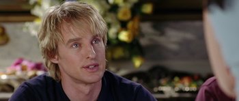 Movie still from “Wedding Crashers” (2005), directed by David Dobkin – A person sitting in front of flowers; Close Up shot, Over the shoulder angle
