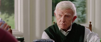 Movie still from “Wedding Crashers” (2005), directed by David Dobkin – An older man with white hair looking at the camera; Close Up shot, Over the shoulder angle