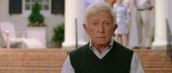 Movie still from “Wedding Crashers” (2005), directed by David Dobkin – An older man with white hair wearing a green vest; Close Up shot, Over the shoulder angle