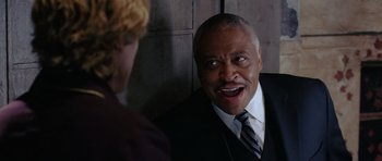 Movie still from “Wedding Crashers” (2005), directed by David Dobkin – An older man wearing a suit and tie talking to a woman; Close Up shot, Over the shoulder angle