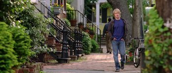 Movie still from “Wedding Crashers” (2005), directed by David Dobkin – A man walking down a sidewalk in a residential area; Wide shot, Over the shoulder angle