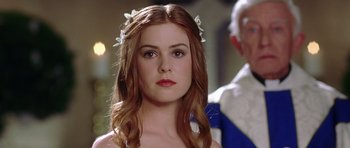 Movie still from “Wedding Crashers” (2005), directed by David Dobkin – A beautiful young woman with long red hair wearing a white flower crown; Close Up shot, Over the shoulder angle