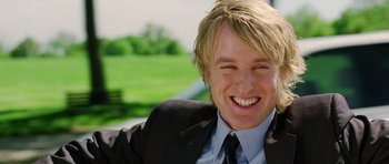 Movie still from “Wedding Crashers” (2005), directed by David Dobkin – A person wearing a suit and tie smiling; Close Up shot, Over the shoulder angle