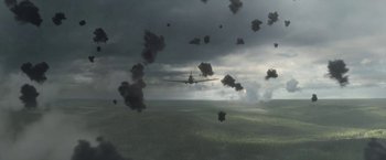 Movie still from “Welcome to Marwen” (2018), directed by Robert Zemeckis – An airplane flying through the sky with black smoke coming out of it; Extreme Wide shot, High angle