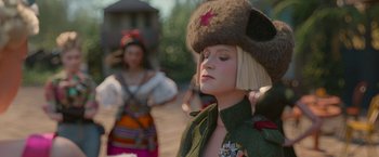 Movie still from “Welcome to Marwen” (2018), directed by Robert Zemeckis – A woman in a military uniform with a hat on; Close Up shot, Over the shoulder angle