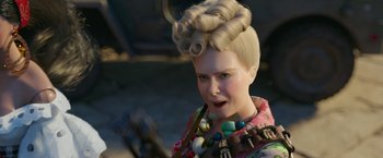 Movie still from “Welcome to Marwen” (2018), directed by Robert Zemeckis – A woman with blonde hair is wearing a necklace; Close Up shot, Over the shoulder angle