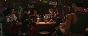 Movie still from “Welcome to Marwen” (2018), directed by Robert Zemeckis – A group of women sitting at a table with drinks; Medium shot, Over the shoulder angle