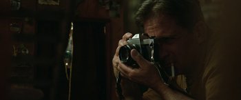 Movie still from “Welcome to Marwen” (2018), directed by Robert Zemeckis – A man taking a picture with a camera; Close Up shot, Low angle
