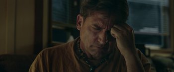 Movie still from “Welcome to Marwen” (2018), directed by Robert Zemeckis – A person holding his hand to his forehead; Close Up shot, Over the shoulder angle