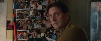 Movie still from “Welcome to Marwen” (2018), directed by Robert Zemeckis – A person in front of a bunch of pictures; Close Up shot, Over the shoulder angle
