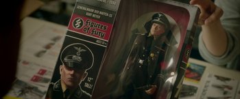 Movie still from “Welcome to Marwen” (2018), directed by Robert Zemeckis – A toy figure of a man wearing a uniform; Medium shot, High angle