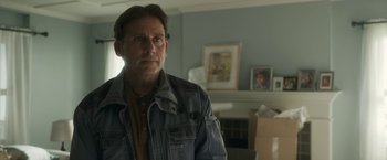 Movie still from “Welcome to Marwen” (2018), directed by Robert Zemeckis – A man standing in front of a mirror in a room; Close Up shot, Over the shoulder angle