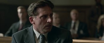 Movie still from “Welcome to Marwen” (2018), directed by Robert Zemeckis – A person wearing a suit and tie; Close Up shot, Over the shoulder angle