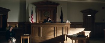 Movie still from “Welcome to Marwen” (2018), directed by Robert Zemeckis – A judge sitting in front of a judge's bench; Wide shot, High angle