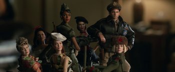 Movie still from “Welcome to Marwen” (2018), directed by Robert Zemeckis – A group of dolls dressed in military uniforms; Medium shot, Overhead angle