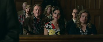 Movie still from “Welcome to Marwen” (2018), directed by Robert Zemeckis – A group of people sitting in front of a wooden table; Medium shot, Over the shoulder angle