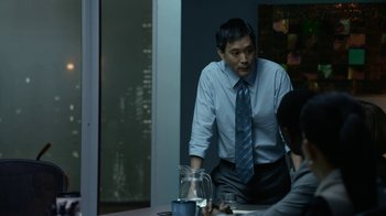 Movie still from “Whiskey Tango Foxtrot” (2016), directed by Glenn Ficarra – A man wearing a blue tie standing at a dinner table; Medium shot, Over the shoulder angle