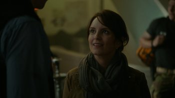 Movie still from “Whiskey Tango Foxtrot” (2016), directed by Glenn Ficarra – A woman wearing a brown jacket and a gray scarf; Close Up shot, Over the shoulder angle