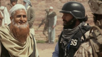 Movie still from “Whiskey Tango Foxtrot” (2016), directed by Glenn Ficarra – A man in a helmet talking to another man in a black vest; Close Up shot, Over the shoulder angle