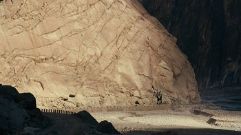 Movie still from “Whiskey Tango Foxtrot” (2016), directed by Glenn Ficarra – A horse is standing in the middle of the desert; Extreme Wide shot, High angle