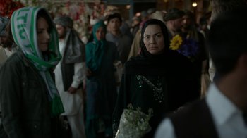 Movie still from “Whiskey Tango Foxtrot” (2016), directed by Glenn Ficarra – A group of people standing in a room with flowers; Close Up shot, Over the shoulder angle