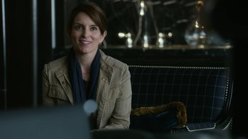 Movie still from “Whiskey Tango Foxtrot” (2016), directed by Glenn Ficarra – A woman sitting on a bench smiling for the camera; Close Up shot, Over the shoulder angle
