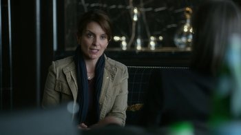 Movie still from “Whiskey Tango Foxtrot” (2016), directed by Glenn Ficarra – A woman sitting at a table in front of a computer; Close Up shot, Over the shoulder angle