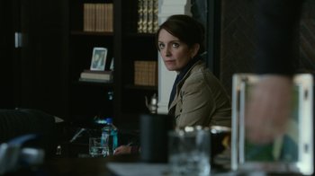 Movie still from “Whiskey Tango Foxtrot” (2016), directed by Glenn Ficarra – A woman sitting at a table with a glass of water in front of her; Close Up shot, Over the shoulder angle