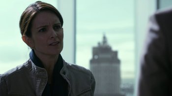 Movie still from “Whiskey Tango Foxtrot” (2016), directed by Glenn Ficarra – A woman standing in front of a large window; Close Up shot, Over the shoulder angle