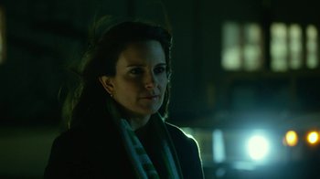 Movie still from “Whiskey Tango Foxtrot” (2016), directed by Glenn Ficarra – A woman with a scarf around her neck is standing in the dark; Close Up shot, Over the shoulder angle