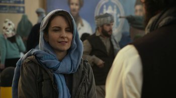 Movie still from “Whiskey Tango Foxtrot” (2016), directed by Glenn Ficarra – A woman with a scarf around her head; Close Up shot, Over the shoulder angle