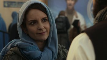 Movie still from “Whiskey Tango Foxtrot” (2016), directed by Glenn Ficarra – A person wearing a scarf on their head; Close Up shot, Over the shoulder angle