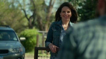 Movie still from “Whiskey Tango Foxtrot” (2016), directed by Glenn Ficarra – A woman standing next to a wooden fence; Medium shot, Over the shoulder angle