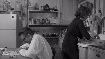 Movie still from “Who's Afraid of Virginia Woolf?” (1966), directed by Mike Nichols – An older man and a woman in a kitchen; Medium shot, Over the shoulder angle