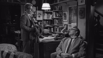 Movie still from “Who's Afraid of Virginia Woolf?” (1966), directed by Mike Nichols – A man in a suit and tie standing next to another man in a suit and tie; Medium shot, Over the shoulder angle