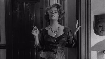 Movie still from “Who's Afraid of Virginia Woolf?” (1966), directed by Mike Nichols – A black and white photo of a woman smoking a cigarette; Medium shot, Low angle