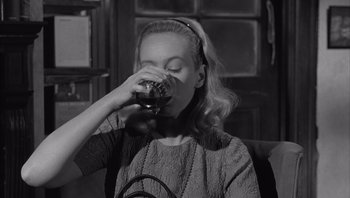 Movie still from “Who's Afraid of Virginia Woolf?” (1966), directed by Mike Nichols – A woman drinking a glass of red wine; Close Up shot, High angle
