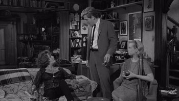 Movie still from “Who's Afraid of Virginia Woolf?” (1966), directed by Mike Nichols – Two women and a man are sitting in a living room; Medium shot, Over the shoulder angle