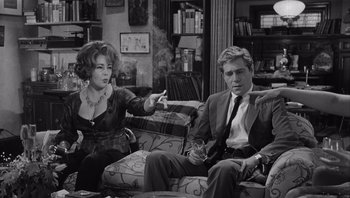 Movie still from “Who's Afraid of Virginia Woolf?” (1966), directed by Mike Nichols – A man and a woman sitting on a couch; Medium shot, High angle