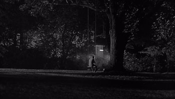 Movie still from “Who's Afraid of Virginia Woolf?” (1966), directed by Mike Nichols – A man sitting on the ground next to a tree; Extreme Wide shot, High angle